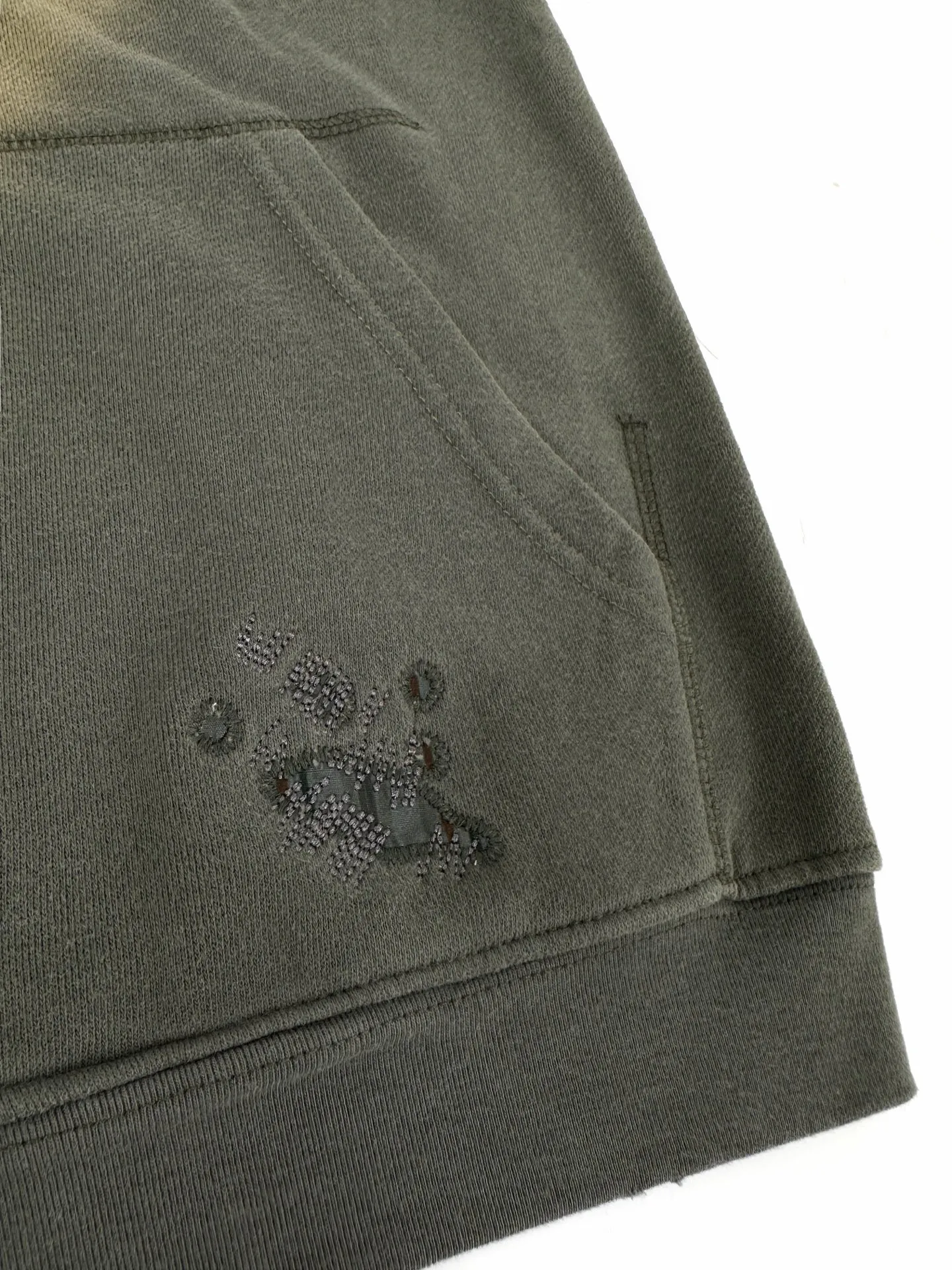 Women's Acn Studios spray-painted distressed logo hooded jacket, custom made of dusk-dyed acid-washed cloud-like fleece cotton, has a smooth drape and is soft and skin-friendly. Wearing a moss gray-green base, water-washed, acid-washed and smudged soft cloth, the matte gray-green creates a relaxed Retro street style. The iconic Acne Studios logo is embellished on the chest, simple yet recognizable. The body is decorated with simulated repair embroidery details in many places to restore the worn texture of old items, giving it a retro texture that has accumulated over time. The zippered hooded silhouette with loose dropped shoulders releases a sense of unrestricted relaxation and unlocks the relaxed retro style. Let Retro narrative blend with modern relaxation, and interpret the non-noisy Retro women's clothing style in subtle ways. 1. Imported machine embroidery uses advanced computer control systems and precision mechanical components to achieve detailed pudding work, with smooth and delicate lines and a full sense of sophistication. 2. Glue printing: Use glue liquid paint to print patterns on the fabric, and bake the fabric to fix the printed pattern. 3. Gradient distressed spray paint. By spraying dyes of different colors on the surface of the fabric, the clothes can show rich color changes under different lights and increase the visual layering. 4. Positioning and wear-and-tear. Many places on the garment body are regularly positioned and worn manually. Manual brush marks are added to the surface of the clothing to add texture and depth to imitate the texture of natural wear and tear. 5. Enzyme washing treatment: The fabrics have been fermented and washed, so they have a better hand feel and texture, are not easy to deform, shrink or fade, and maintain long-term beauty. Accessories: Customized 1:1 Acne zipper Customized 1:1 Acne trademark Version: Loose version Size: S M L Style number: 88FF